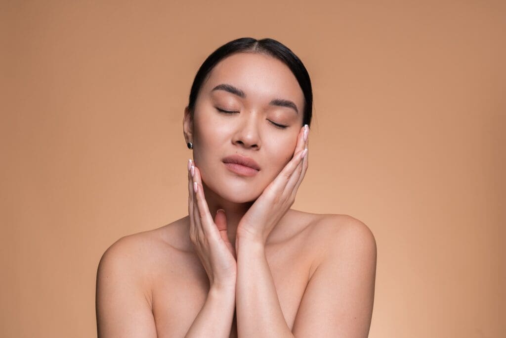Relaxed Woman Posing for Beauty Portrait With Natural Glow on Tan Background